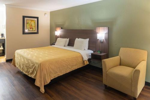 ein Hotelzimmer mit einem Bett und einem Stuhl in der Unterkunft Quality Inn Richmond Hill - Savannah I-95 in Richmond Hill