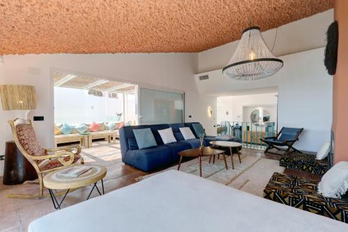 een woonkamer met een blauwe bank en stoelen bij Bahia Dorada by the sea in Estepona