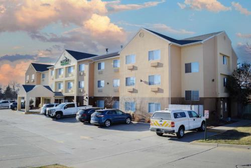a large building with cars parked in a parking lot at Wingate by Wyndham Great Falls in Great Falls