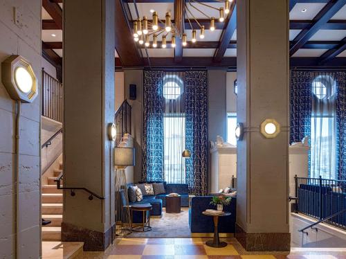 a lobby with a blue couch and a chandelier at Holston House Nashville, in The Unbound Collection by Hyatt in Nashville