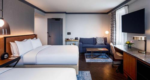 a hotel room with a bed and a couch at Holston House Nashville, in The Unbound Collection by Hyatt in Nashville