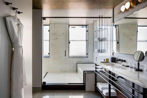 a white bathroom with a shower and a sink at Holston House Nashville, in The Unbound Collection by Hyatt in Nashville