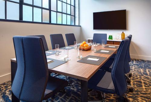 a conference room with a large wooden table and chairs at Holston House Nashville, in The Unbound Collection by Hyatt in Nashville