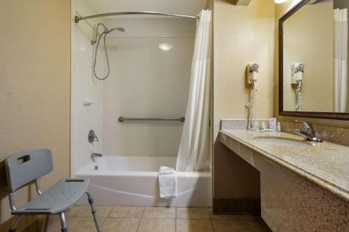 Un baño con bañera, lavabo y ducha. en Quality Inn & Suites, en West Helena