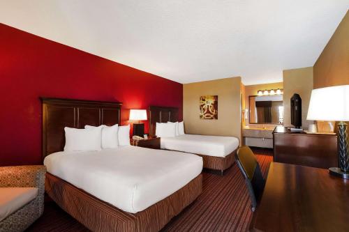 Una habitación de hotel con dos camas y un escritorio. en Quality Inn & Suites, en West Helena