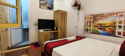 ein Schlafzimmer mit einem Bett und einem Wandgemälde in der Unterkunft Thanh Hương 99 Hotel - Nội Bài in Hanoi