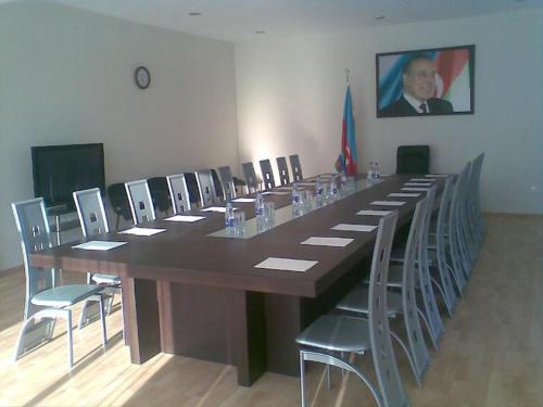 a large long table with chairs and a man in a picture at Arena Hotel Gusar in Qusar