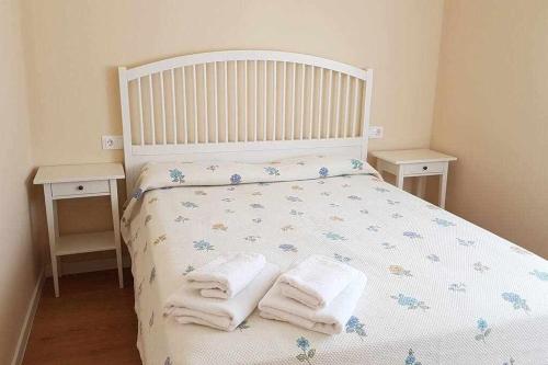 Un dormitorio con una cama blanca con toallas. en Fantástico apartamento junto a la Judería, en Córdoba
