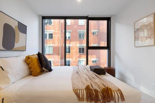 een slaapkamer met een groot bed en een groot raam bij Nice 2-bed rental unit with free parking in Melbourne