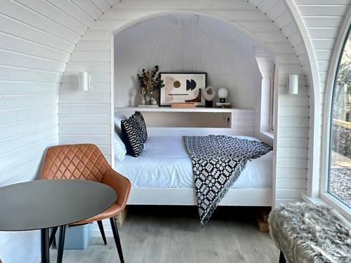 um quarto com uma cama num quarto branco em Y Caban - A Luxury Rural Retreat with Seaviews em Amlwch