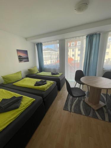 Habitación con 2 camas, mesa, mesa y sillas. en City-Pension-Dortmund en Dortmund
