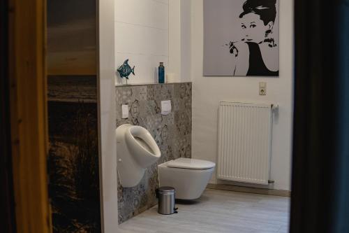 łazienka z pisuarem i toaletą w obiekcie Zimmerfrei-Barz w mieście Ahlefeld