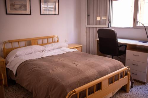 1 dormitorio con cama, escritorio y silla en Apartamento para familias con niños cerca Playa, en San Juan de Alicante
