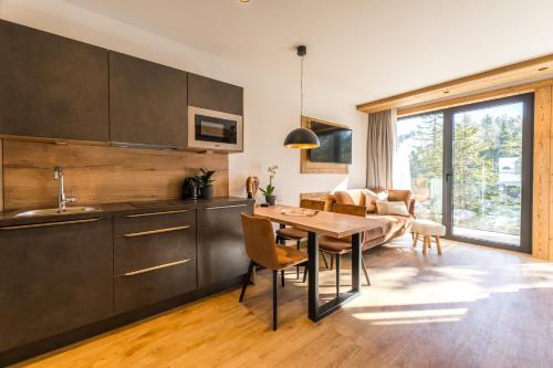 a kitchen and living room with a table and a couch at Alpin Peaks in Turracher Hohe