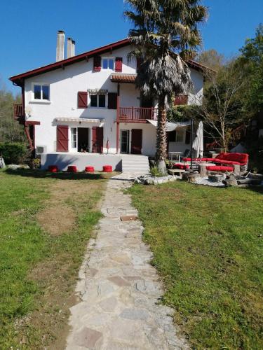 a house with a palm tree in front of it at Maison basque à 8 minutes des plages in Ahetze