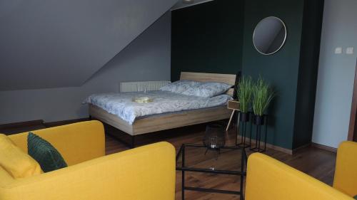sypialnia z łóżkiem i 2 żółtymi krzesłami w obiekcie Zielone Tarasy na Kaszubach w mieście Sikorzyno