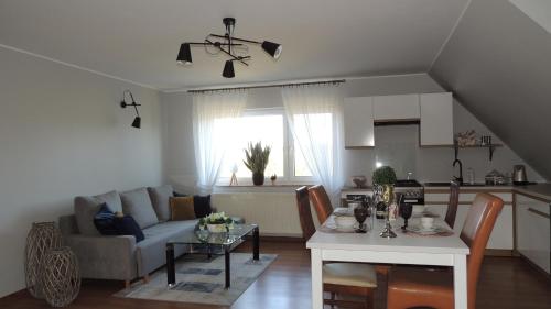 a living room and kitchen with a couch and a table at Zielone Tarasy na Kaszubach in Sikorzyno