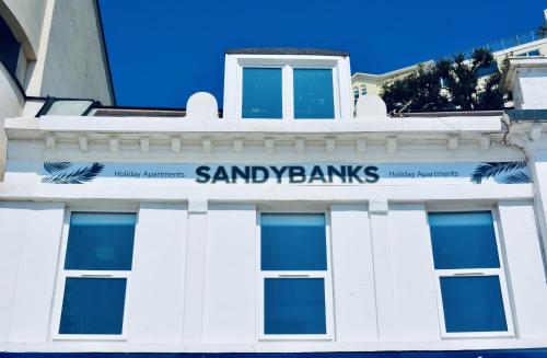 a sign on the side of a white building at Sandybanks Torquay - Seaview and Promenade Apartments in Torquay