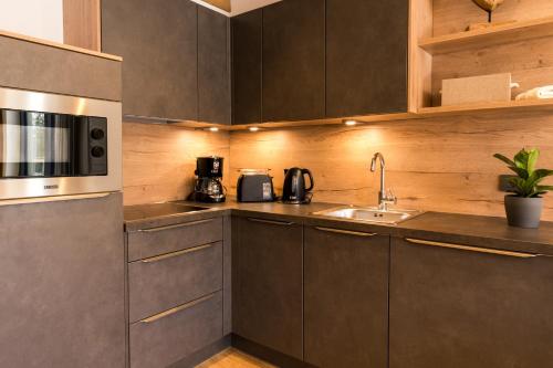 a kitchen with a sink and a microwave at Alpin Peaks in Turracher Hohe