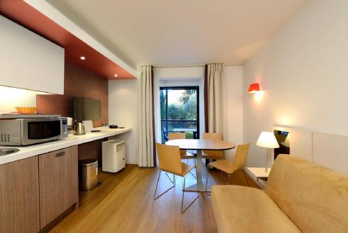 una cucina e un soggiorno con divano e tavolo di Résidence Residéal Premium Cannes a Cannes