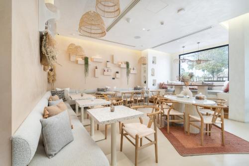 Beach Walk Boutique Jumeirah في دبي: مطعم فيه طاولات وكراسي في الغرفة