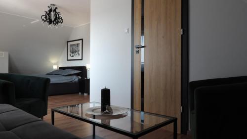 a living room with a couch and a glass table at Zielone Tarasy na Kaszubach in Sikorzyno