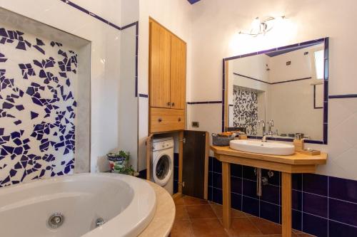 uma casa de banho com uma banheira, um lavatório e uma máquina de lavar roupa em Ca' di Buizan em Boissano