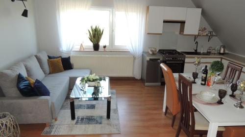 a living room with a couch and a table at Zielone Tarasy na Kaszubach in Sikorzyno