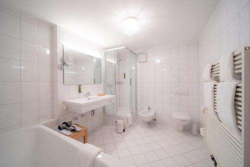 a white bathroom with a sink and a toilet at Marina Hotel am Starnberger See in Bernried
