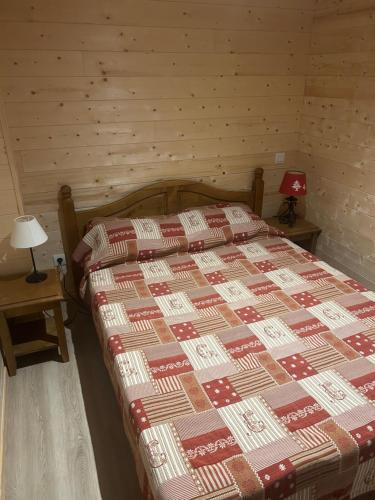 een slaapkamer met een bed met een rode en bruine quilt bij Appartement 4 personnes - Hautes-Pyrénées- Village de Peyragudes Peyresourdes - Vue exceptionnelle sur la montagne in Germ