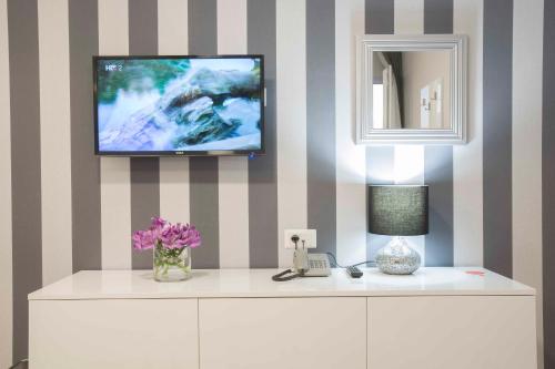 a room with a tv on a striped wall at Boutique Hotel Intermezzo - Pag centre in Pag
