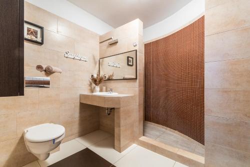a bathroom with a toilet and a sink at Flatbook Apartamenty - Sztutowo Lazurowy Dwór in Sztutowo