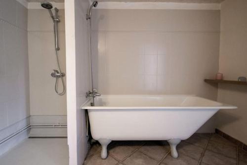 La salle de bains est pourvue d'une baignoire blanche et d'une douche. dans l'établissement Little Beauty Yourhosthelper, à Villedaigne