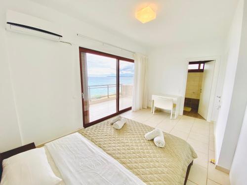 a bedroom with a bed with a view of the ocean at Elenos Villa in Possidi