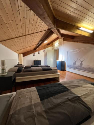 ベリンツォーナにあるホテル クローチェ フェデラーレの木製の天井が特徴のベッドルーム1室(ベッド2台付)