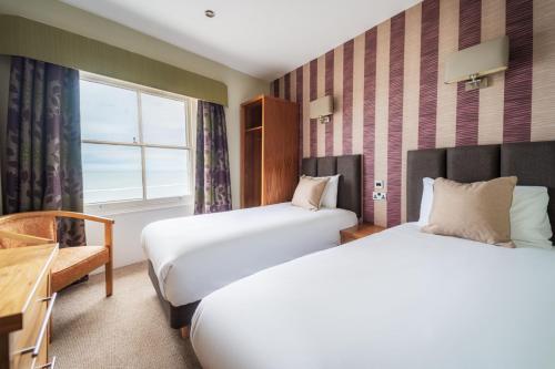 a hotel room with two beds and a window at Esplanade Hotel Llandudno in Llandudno