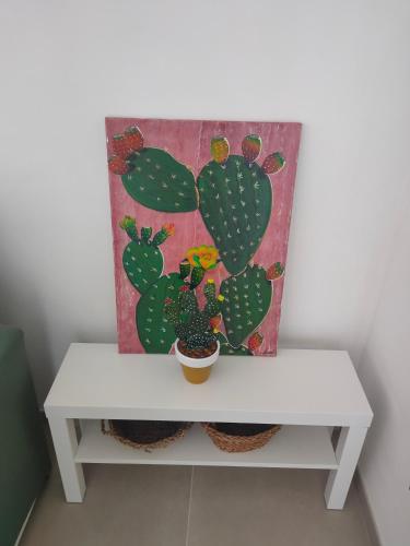 a white table with a painting of cactus at La casetta del Fico d'India in Marsala