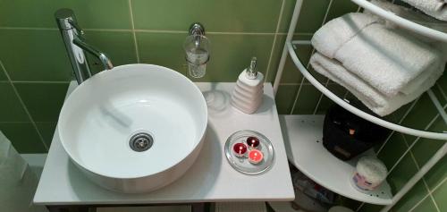 a bathroom with a white sink and towels at Apartman Studio DIAMOND in Subotica
