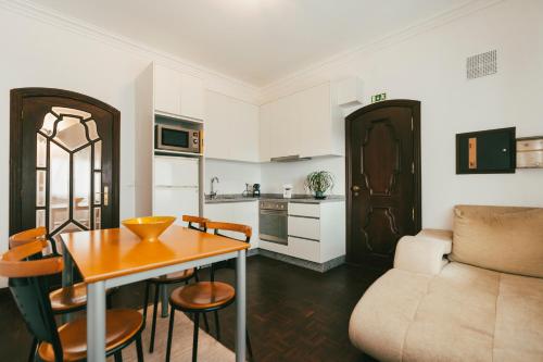 eine Küche und ein Wohnzimmer mit einem Tisch und einem Sofa in der Unterkunft Quinta da Costinha in Alijó