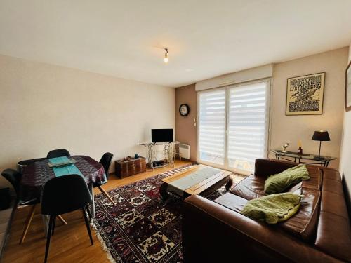 un salon avec un canapé et une table dans l'établissement Appart du bourg, proximité & mer, à Saint-Jean-de-Monts