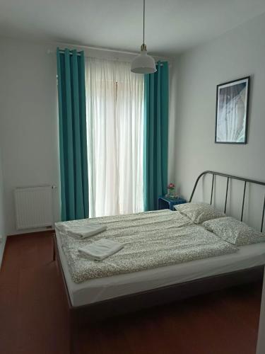 a bedroom with a large bed with green curtains at Platan 3 in Świnoujście