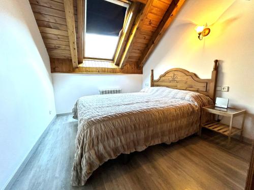 1 dormitorio con 1 cama grande en una habitación con ventana en Dúplex lluminós a Esterri d'Àneu by RURAL D'ÀNEU, en Esterri d'Àneu