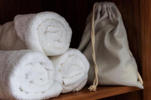 a pile of towels on a shelf with a purse at Esplanade Hotel Llandudno in Llandudno