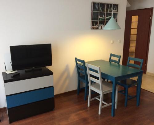 a dining room with a table and chairs and a television at Platan 3 in Świnoujście