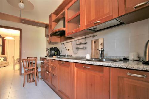 a kitchen with wooden cabinets and a counter top at Appartamento - PUNTA SABBIONI in Cavallino-Treporti