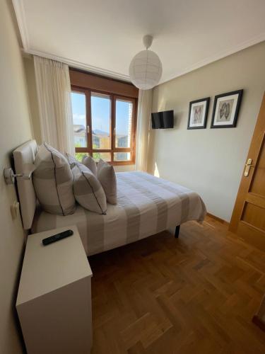 a bedroom with a bed and a large window at Apartamento Cueto in Soto del Barco