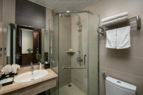 a bathroom with a sink and a shower at Halios Luxury Halong Hotel in Ha Long