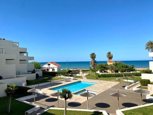 a view of a resort with a swimming pool and the ocean at Tierra de Mar VYBdenia in Denia