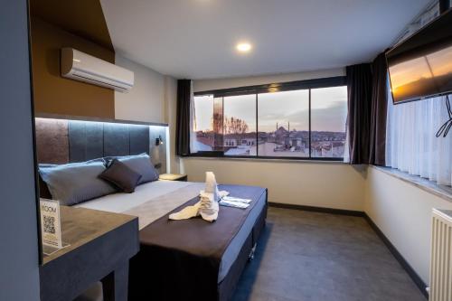 a bedroom with a bed and a large window at The Queen Hotel in Istanbul