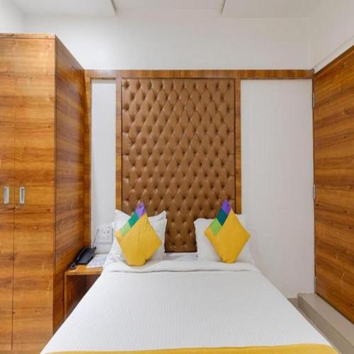 a bedroom with a large white bed with yellow pillows at Hotel Riva International Goregaon- Near NESCO in Mumbai